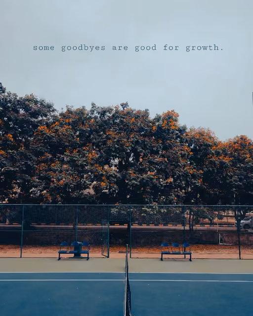 Empty tennis court with net, bordered by a chain-link fence, two blue benches, and trees with orange blossoms under a pale sky with text overlay.